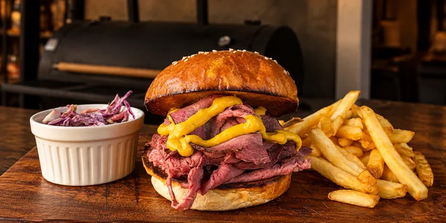 Bánh mì kẹp thịt với mù tạt, khoai tây chiên và xà lách bắp cải
