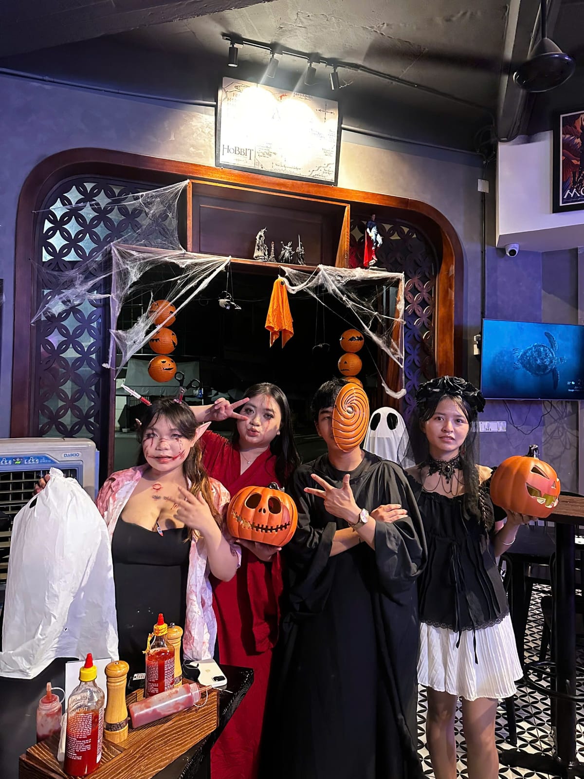 Guests in Halloween costumes gathered beneath decorations at The Social