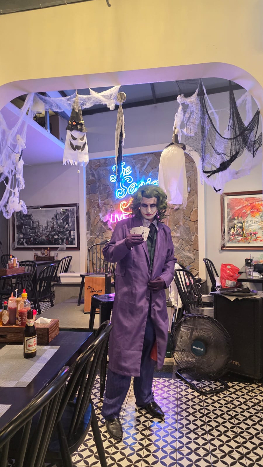 Guest in a Joker costume beneath Halloween decorations at The Social